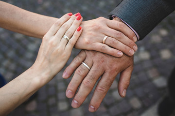 two female hands on the man's hand