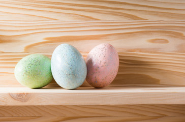 glitter colorful easter eggs on pine wood shelf