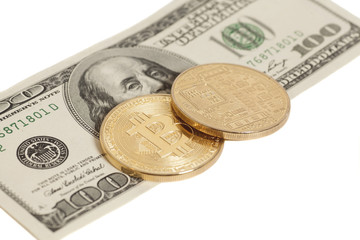 Golden bitcoin coins and one hundred dollar banknote