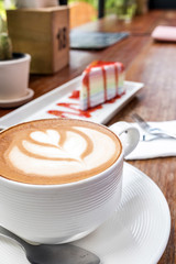 Cup of hot latte art coffee on wooden table