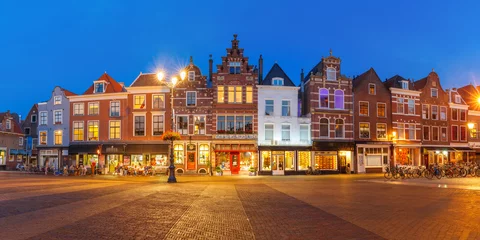 Foto auf Glas Panorama of typical Dutch houses on the Markt square in the center of the old city at night, Delft, Holland, Netherlands © Kavalenkava