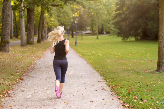 Fit active young woman jogging through a park