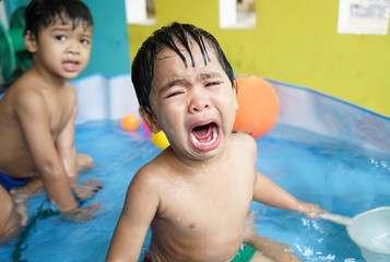 Little boy crying bitterly in the pool