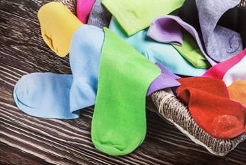 scattered multi-colored socks and laundry basket