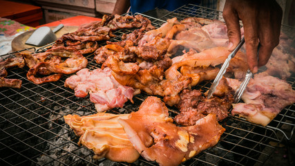 Vender selling roasted pork thai style local market at temple in Bangkok , Asia , Thailand