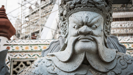 The beautiful of  stone Thai-Chinese style sculpture and thai art architecture in Wat Arun buddhist temple in Bangkok, Thailand/Selective focus.