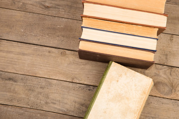 Old and used hardback books or text books on wooden table