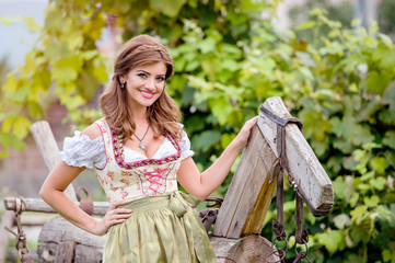 Fototapeta premium Woman in traditional bavarian dress sitting on wooden horse