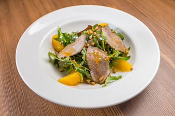 salad with baked duck on white plate