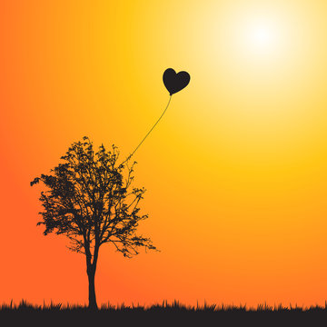 A heart balloon stuck in a tree.