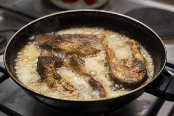 fish frying in a pan