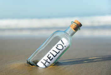 Bottle on the beach with greeting, hello