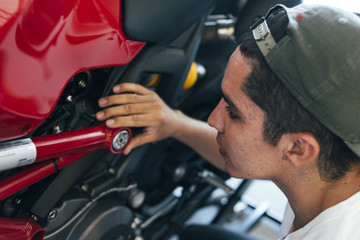 man looking at his motorcycle