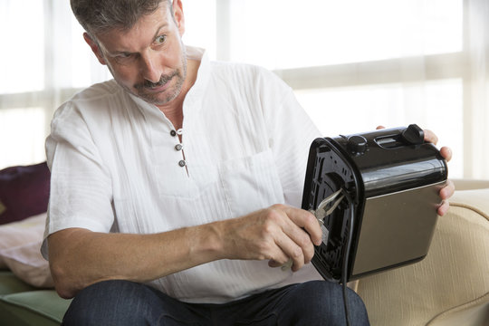 Middle Aged Man Fixing A Toaster