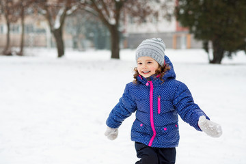 Cute little girl playing outside in winter nature