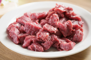 raw fresh sliced beef for beefsteaks in plate on kitchen table