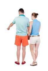 young couple in shorts and t-shirt pointing. Back view.  Rear view people collection.  backside view of person.  Isolated over white background.