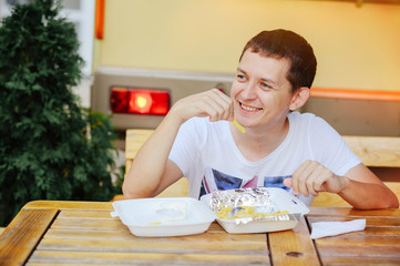man eating French fries and smiling
