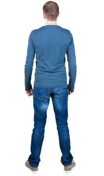 Back view of young man in t-shirt and jeans  looking.   Standing young guy. Rear view people collection.  backside view of person.  Isolated over white background.
