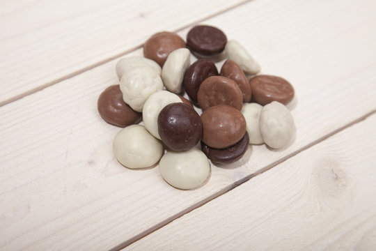 Pile of Dutch candy chocolate pepernoten on white wooden background