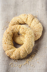 Two homemade bagels with sesame on a gray canvas