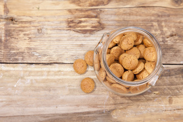 Traditional Dutch candy pepernoot in glass jar on wooden background