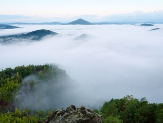 Magnificent heavy mist in landscape. Autumn creamy fog in countryside. Hill increased from fog,