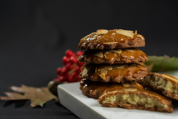 Typical Dutch filled spicy  cookies with almonds on autumn colored and dark background
