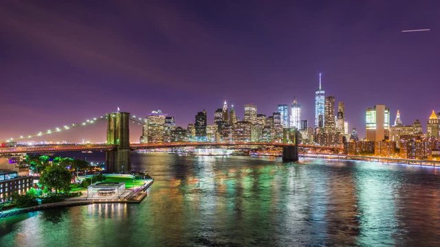 New York City, USA skyline time lapse over the East River at night.