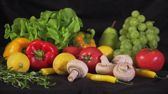 Colorful mix of fruits and vegetables on black velvet background
