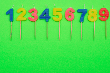 Birthday candles numbers 1 to 9 isolated on a green background