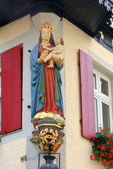 A statue of a Madonna on the facade of a traditional house in Rothenburg ob der Tauber in Germany