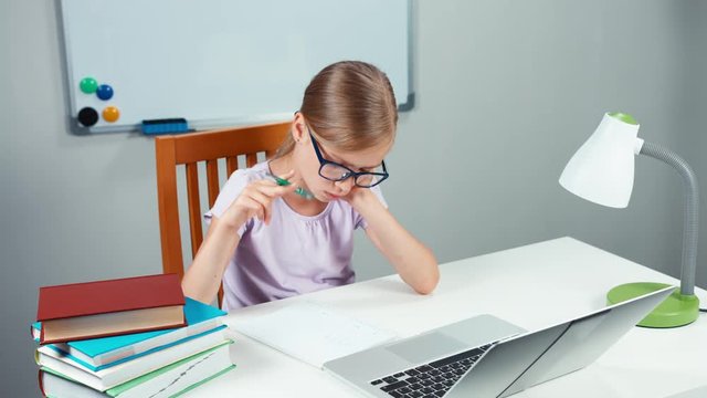 Schoolgirl 7-8 years doing homework in mathematics in her desk