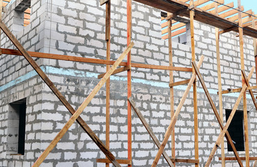 Fototapeta premium Fragment of unfinished building with scaffolding