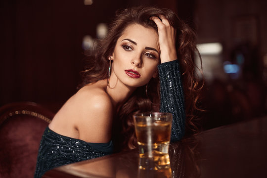 Beauty young brunette woman sitting at the bar