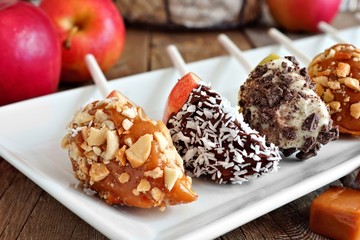 Plate of mixed sweet caramel and chocolate dipped apple slices, close up scene