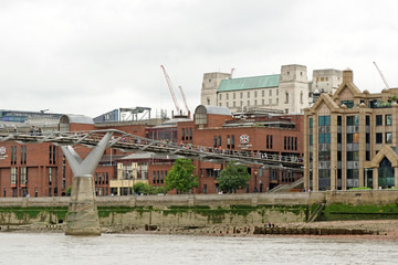 Tourists crossing the Millennium Bridge linking the City of London with the South Bank between St Paul Cathedral and Tate Modern art gallery.