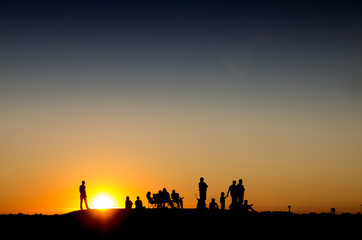 Group of people watching sunset on a mountain