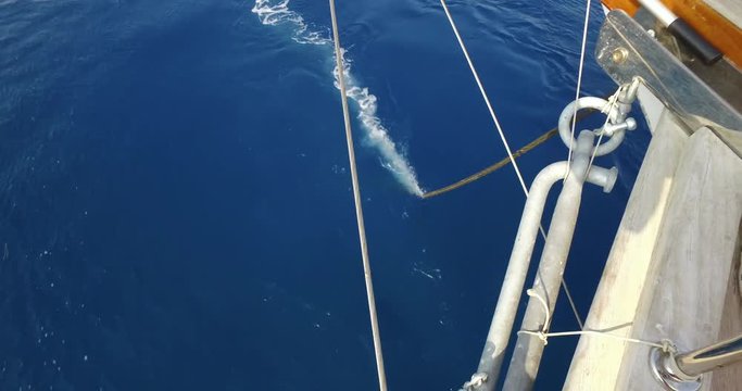 Yacht bow with anchor being released into the sea