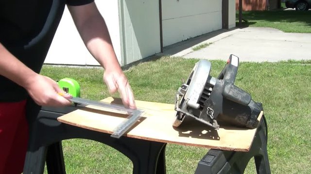 Man Measuring and Cutting Wood