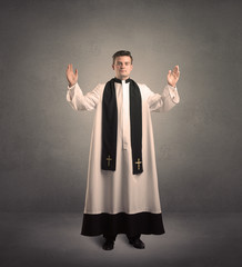 young priest in giving his blessing - obrazy, fototapety, plakaty