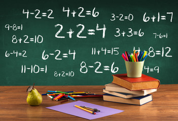 School blackboard with pile of books