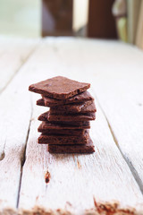 Close up of crunchy wafer thin brownies on a wooden table.
