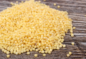 Heap of millet groats on wooden background