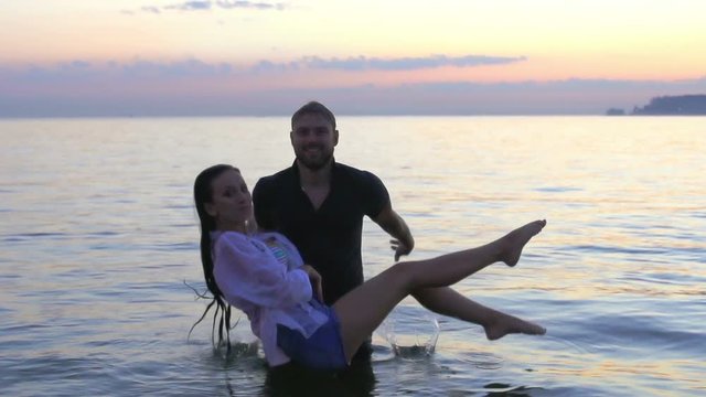 Guy holds girl on hands and throws it into the sea in slomo. Man throws woman the water and creates splashe in slow motion 1080p. Boy kill female slo-mo 1920x1080. Boyfriend disagreement girlfriend.