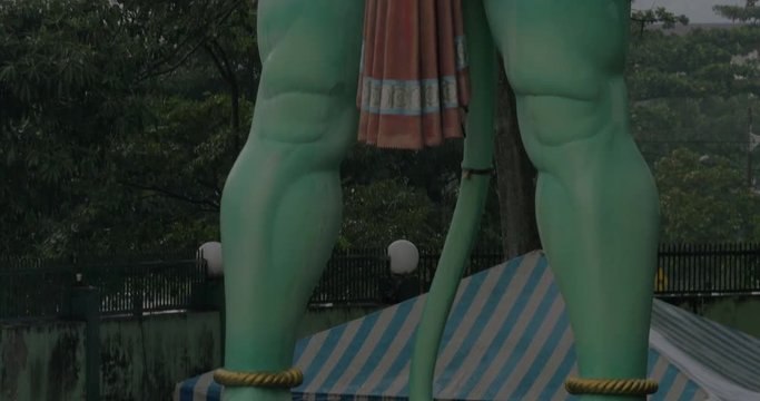 Tilt shot of huge 15m Hanuman statue in Batu Caves on rainy day. Hindu shrine in Malaysia