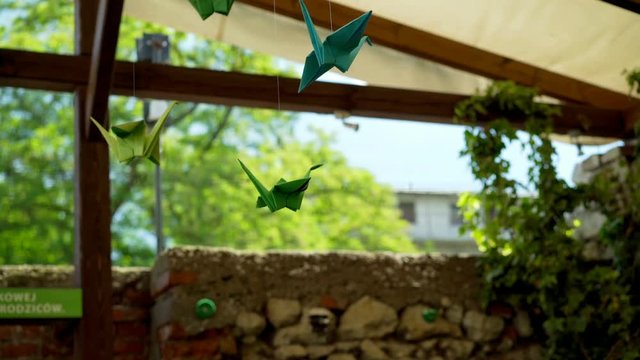 View of the green, origiami birds hanging on the cafe's roof
