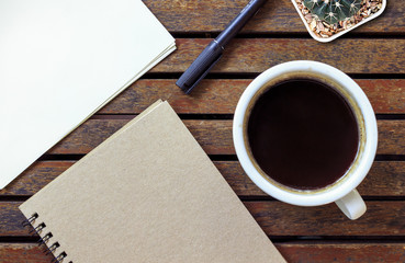 office workplace with keyboard notepad mouse coffee of cup on wooden table. over light