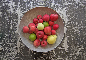 Silver color metal bowl with red apples