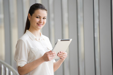 Obraz premium Young businesswoman standing by window in office. 